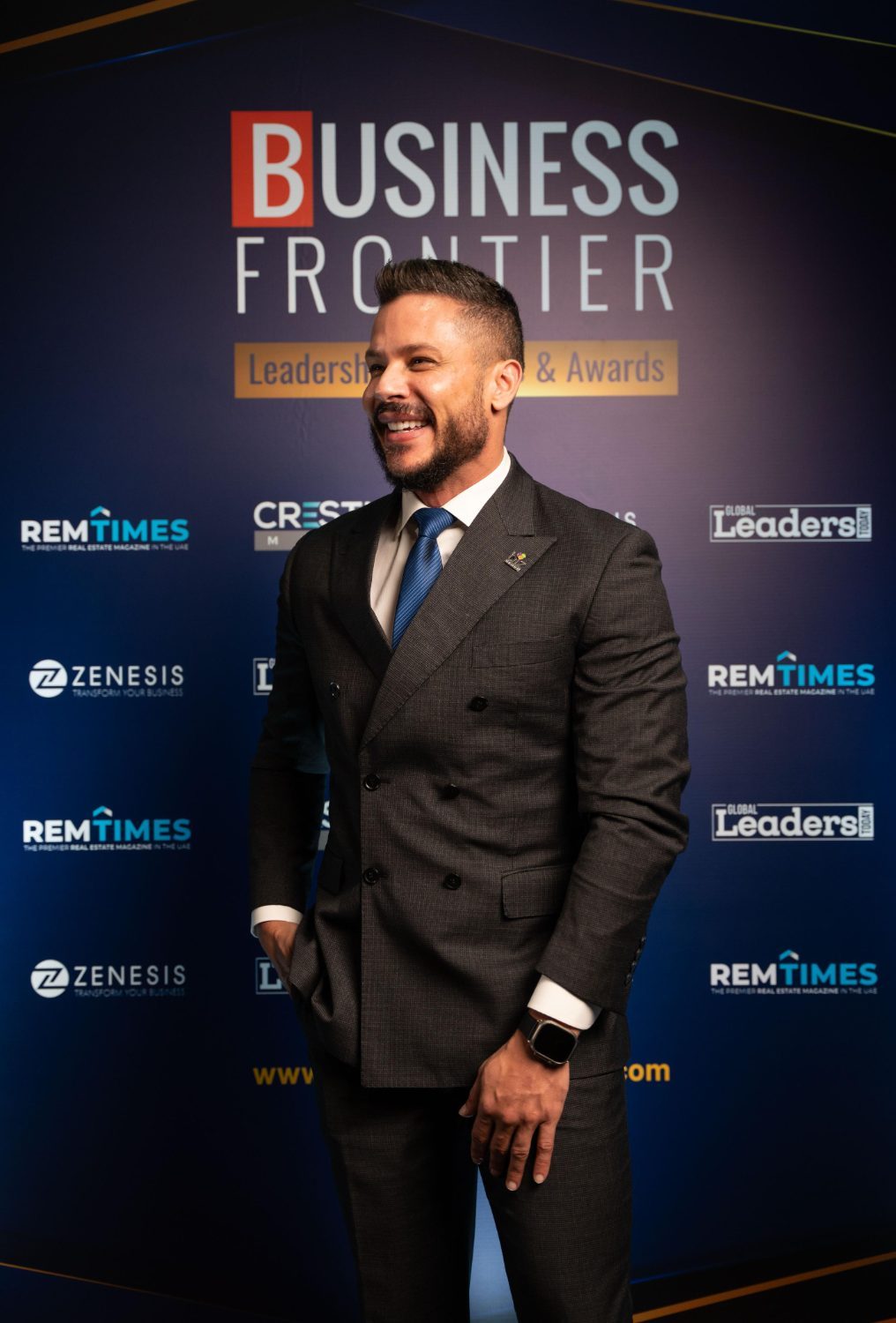Andrew Wolhuter laughing in front of an awards backdrop
